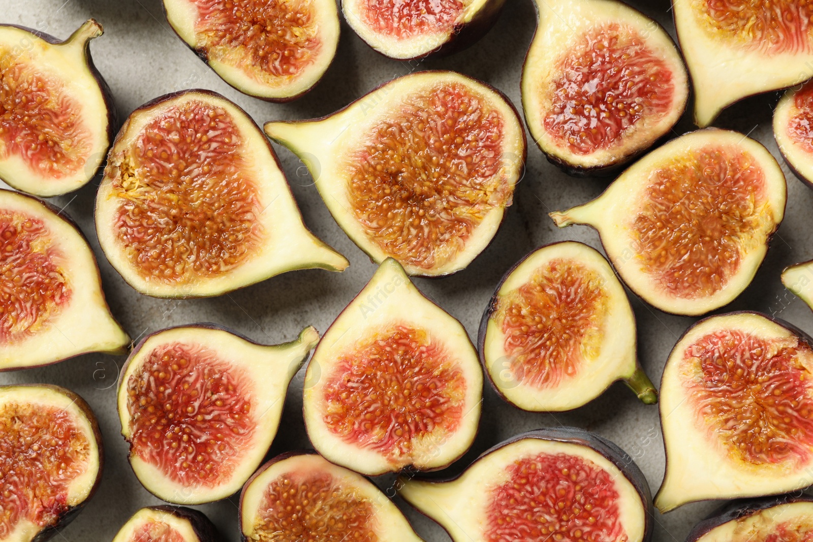 Photo of Delicious cut raw figs on light grey table, flat lay