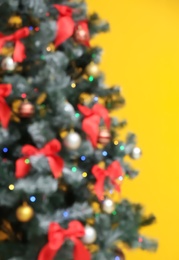 Blurred Christmas tree against color background. Celebration time