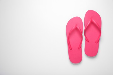 Stylish pink flip flops on white background, top view. Space for text