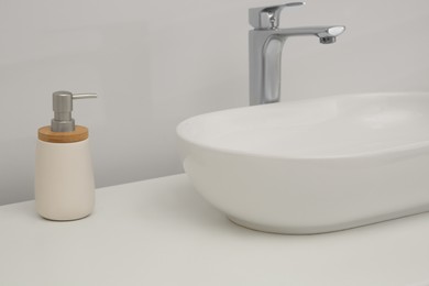 White washbasin and soap dispenser in bathroom. Interior design