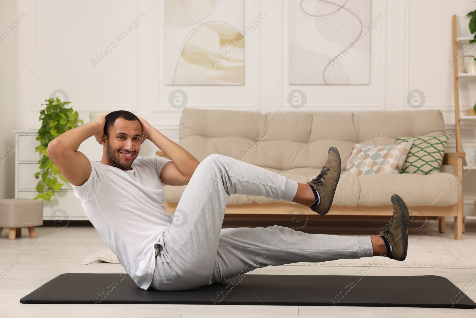 Photo of Man doing morning exercise on fitness mat at home