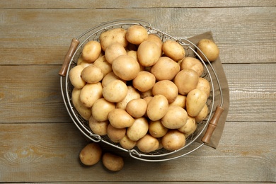 Raw fresh organic potatoes on wooden background, top view