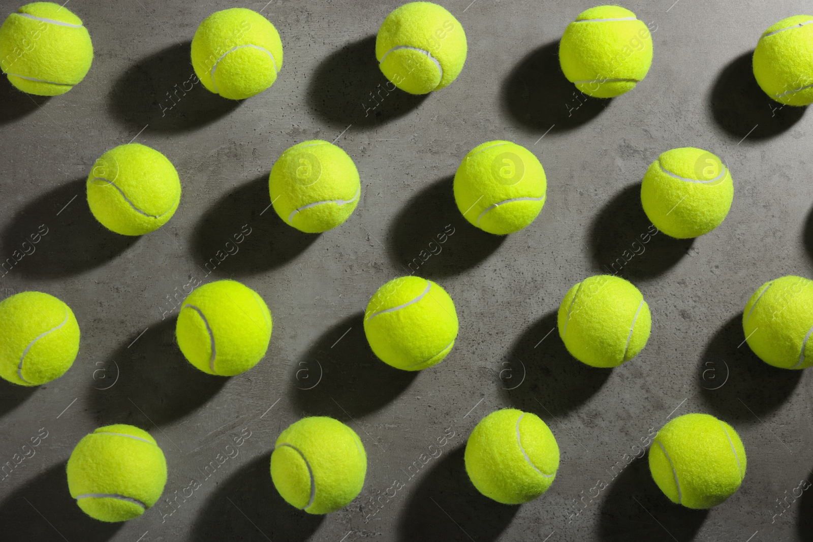 Photo of Tennis balls on grey table, flat lay. Sports equipment