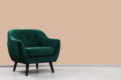 Photo of Stylish armchair near beige wall indoors, space for text