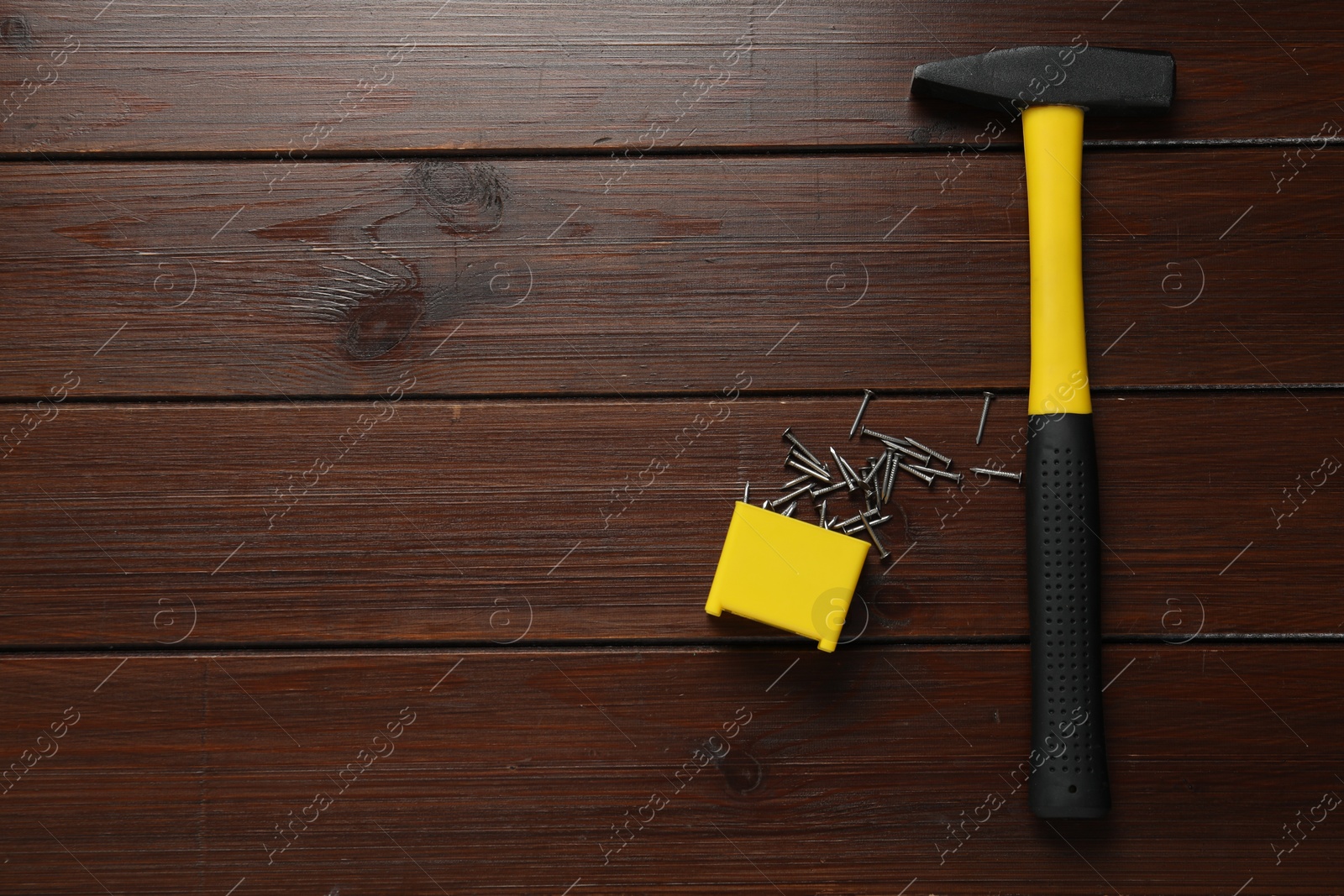 Photo of New hammer and metal nails on wooden table, flat lay. Space for text