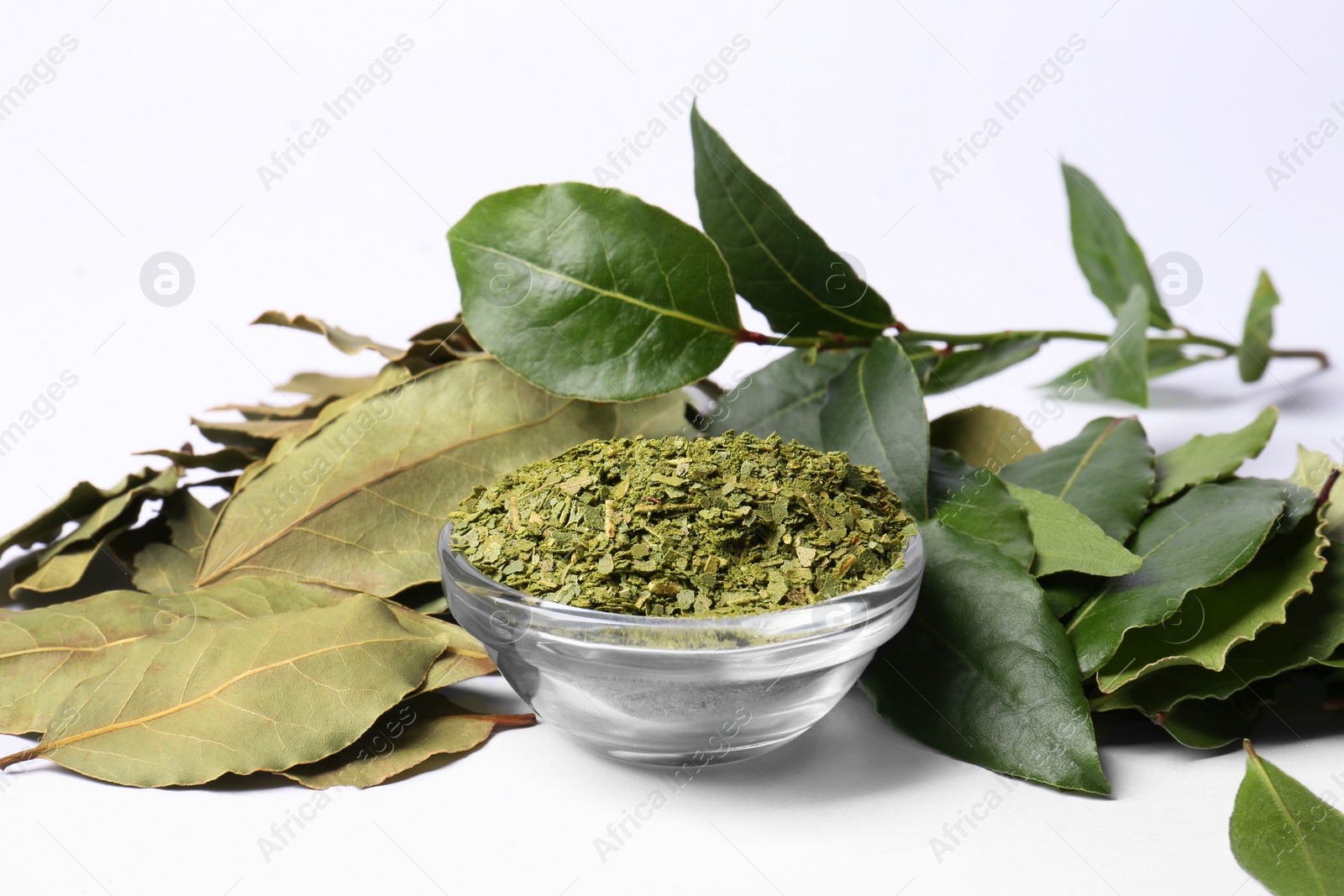 Photo of Fresh and ground bay leaves on white background