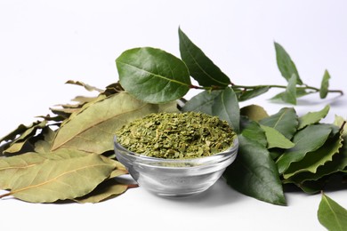 Fresh and ground bay leaves on white background