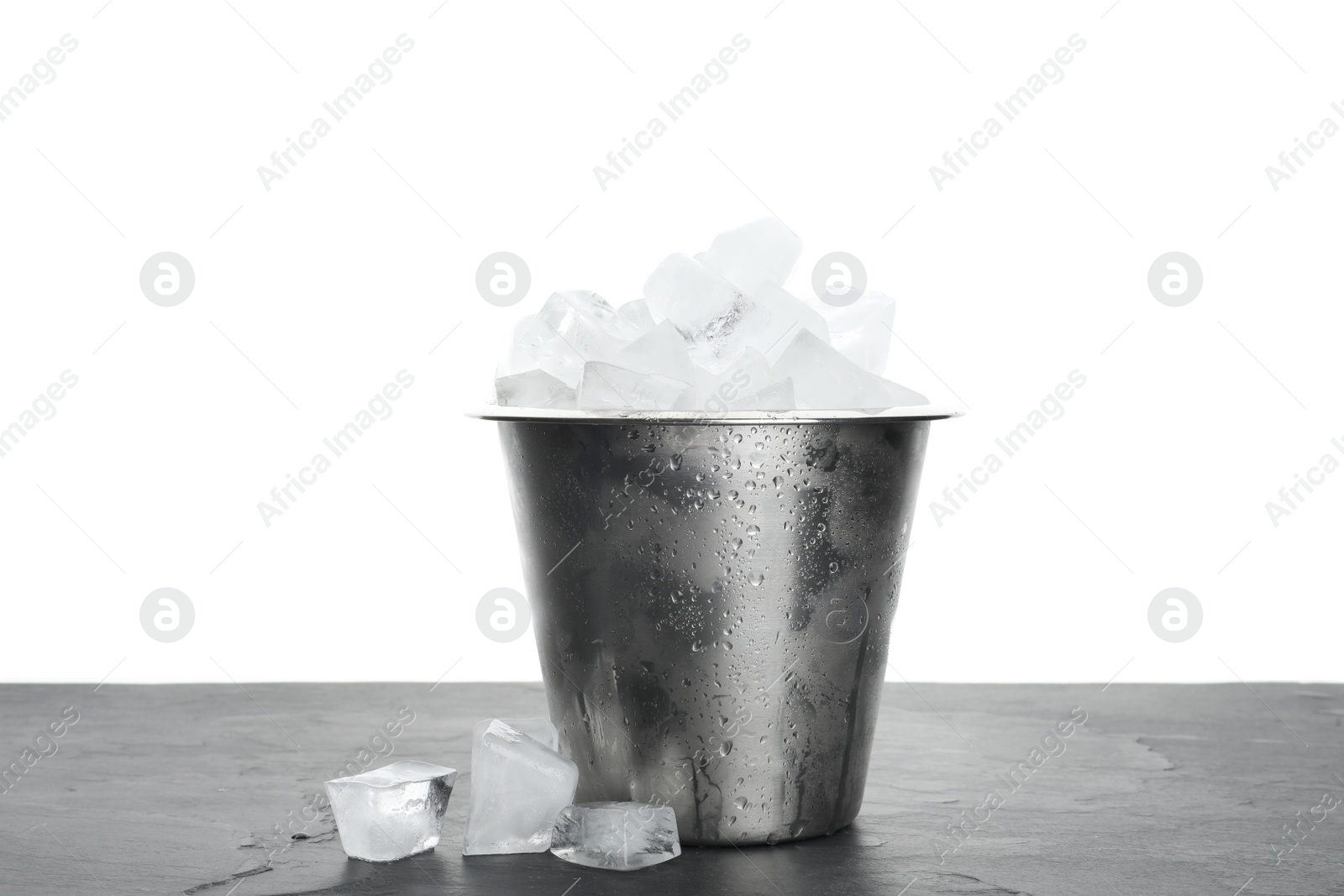 Photo of Metal bucket with ice cubes on table against white background