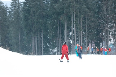 Photo of People sliding on slope at ski resort. Winter vacation