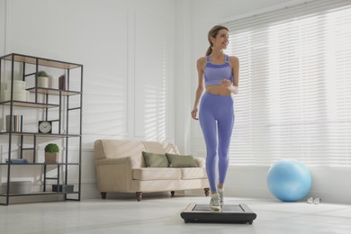 Sporty woman training on walking treadmill at home