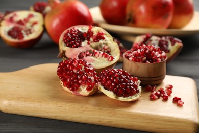 Delicious ripe pomegranates on grey wooden table