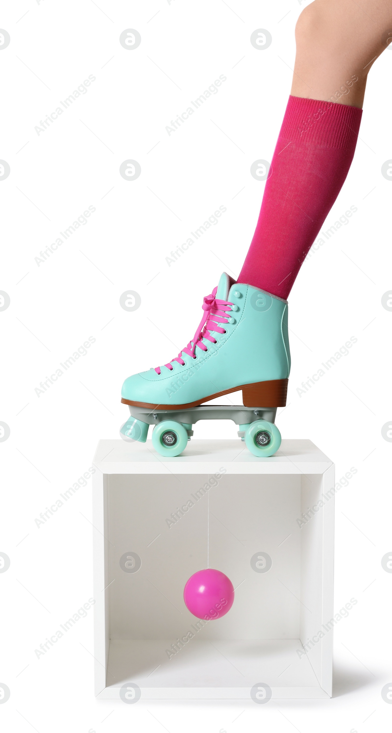 Photo of Woman wearing vintage roller skate and storage cube with ball on white background, closeup