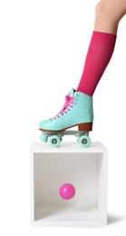 Photo of Woman wearing vintage roller skate and storage cube with ball on white background, closeup