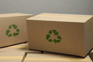 Image of Cardboard boxes with recycle sign stamps on grey background