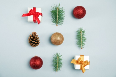 Flat lay composition with Christmas tree branches, decor and gift boxes on gray background