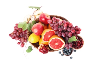 Wicker basket with different fruits and berries on white background, top view