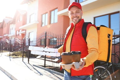 Male courier delivering food in city on sunny day