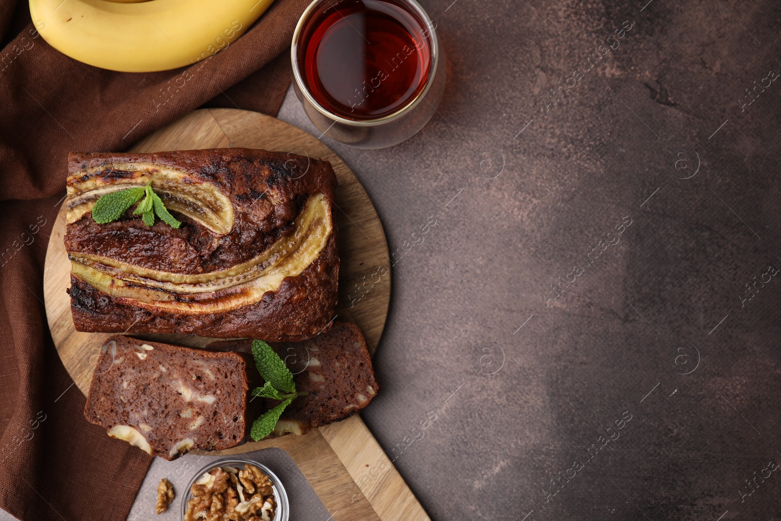 Photo of Delicious banana bread served on brown table, flat lay. Space for text