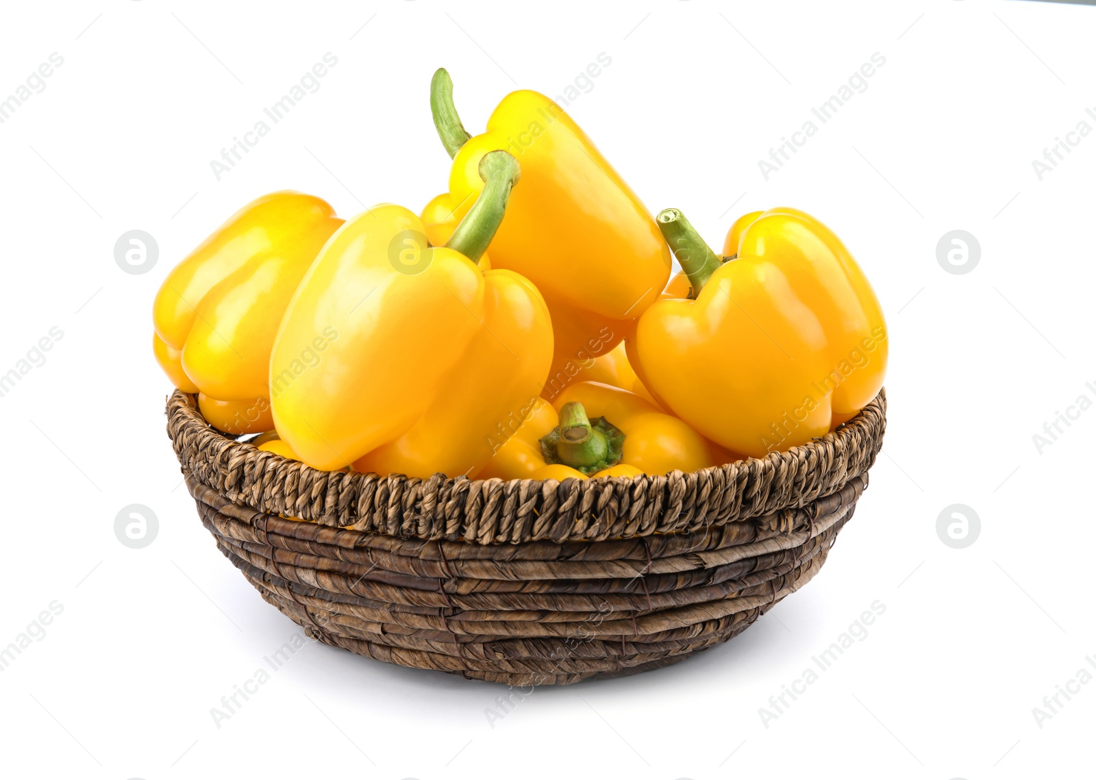 Photo of Wicker bowl of ripe yellow bell peppers isolated on white