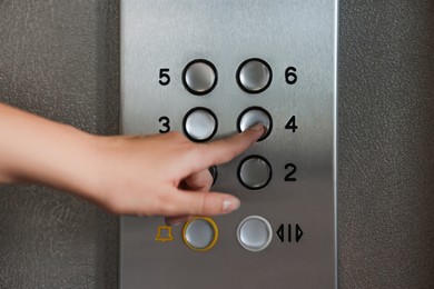 Woman choosing floor in elevator, closeup view