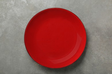 Photo of Empty burgundy ceramic plate on grey table, top view