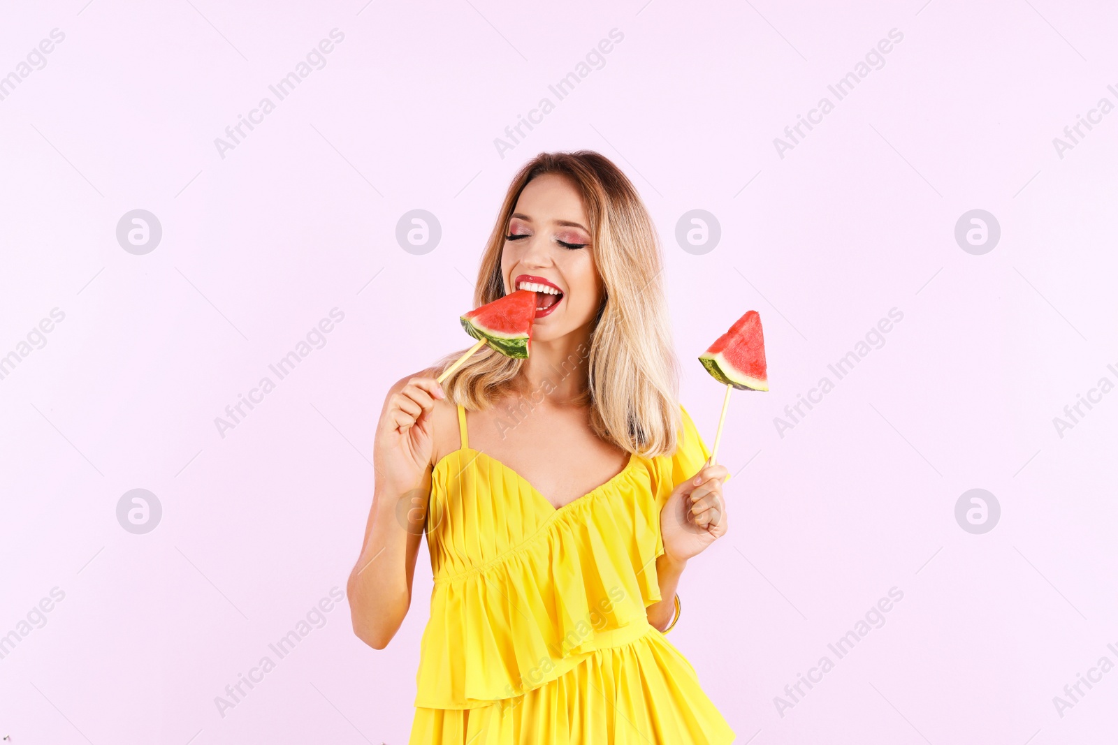 Photo of Pretty young woman with juicy watermelon on color background