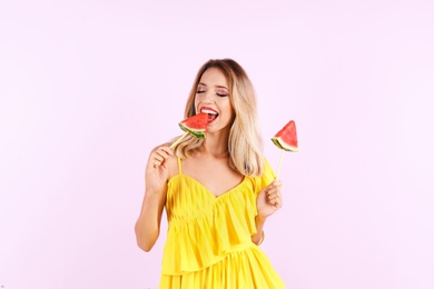 Pretty young woman with juicy watermelon on color background