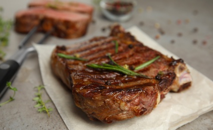 Photo of Grilled meat steak on grey table, closeup