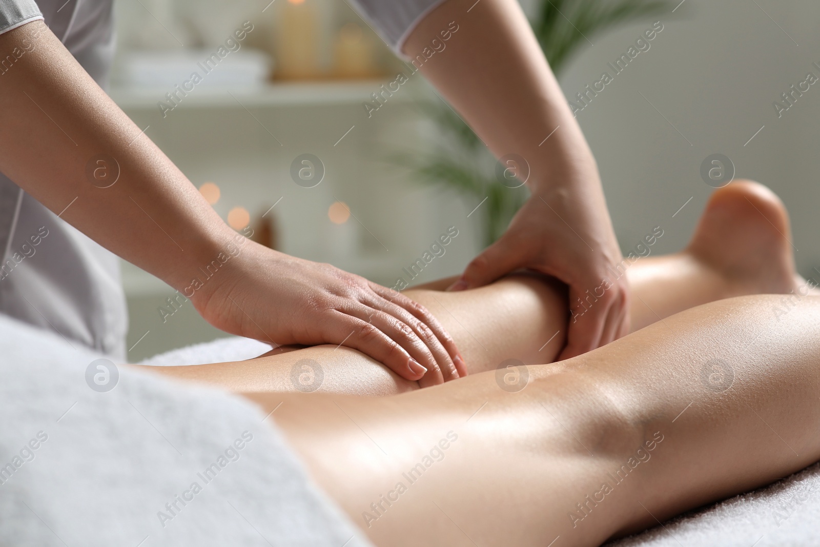 Photo of Woman receiving leg massage in spa salon, closeup