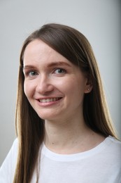 Portrait of beautiful happy woman on light grey background