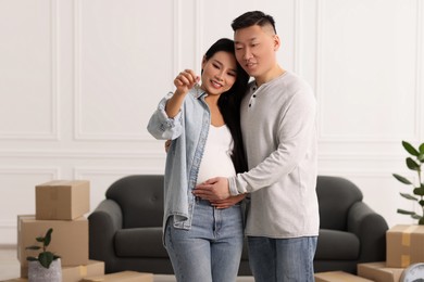 Pregnant woman and her husband with key in their new apartment