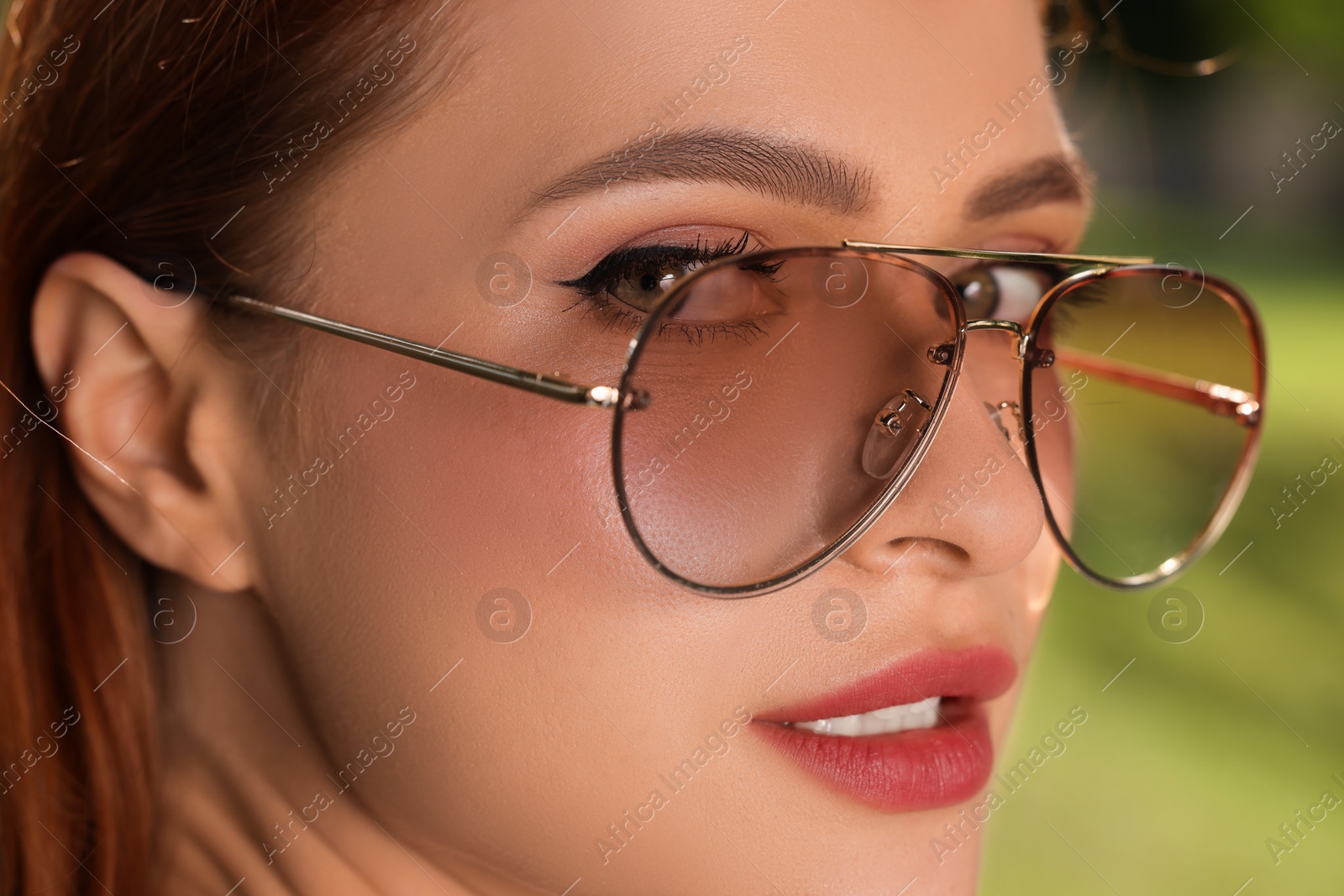 Photo of Beautiful woman in sunglasses outdoors on sunny day, closeup