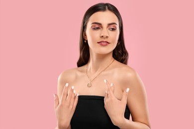 Photo of Beautiful woman with elegant necklace on pink background