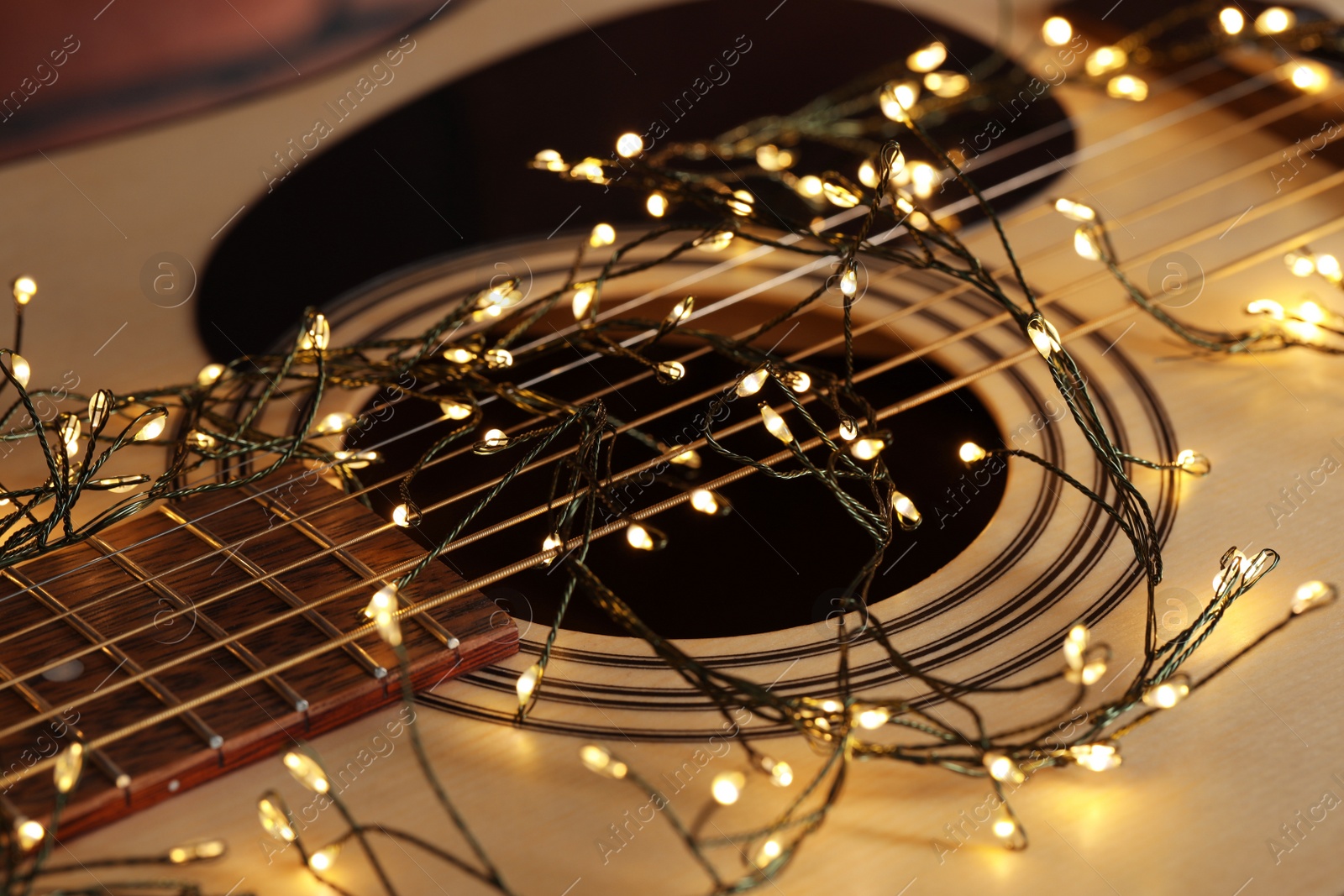 Photo of Closeup view of guitar with fairy lights
