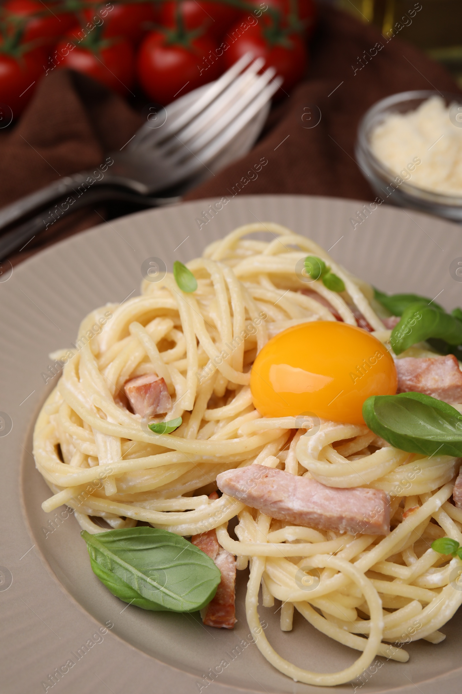 Photo of Delicious pasta Carbonara with egg yolk on plate, closeup