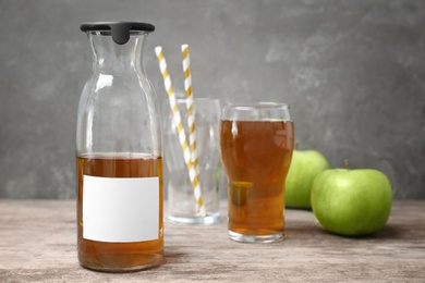 Photo of Bottle of fresh apple juice on wooden table