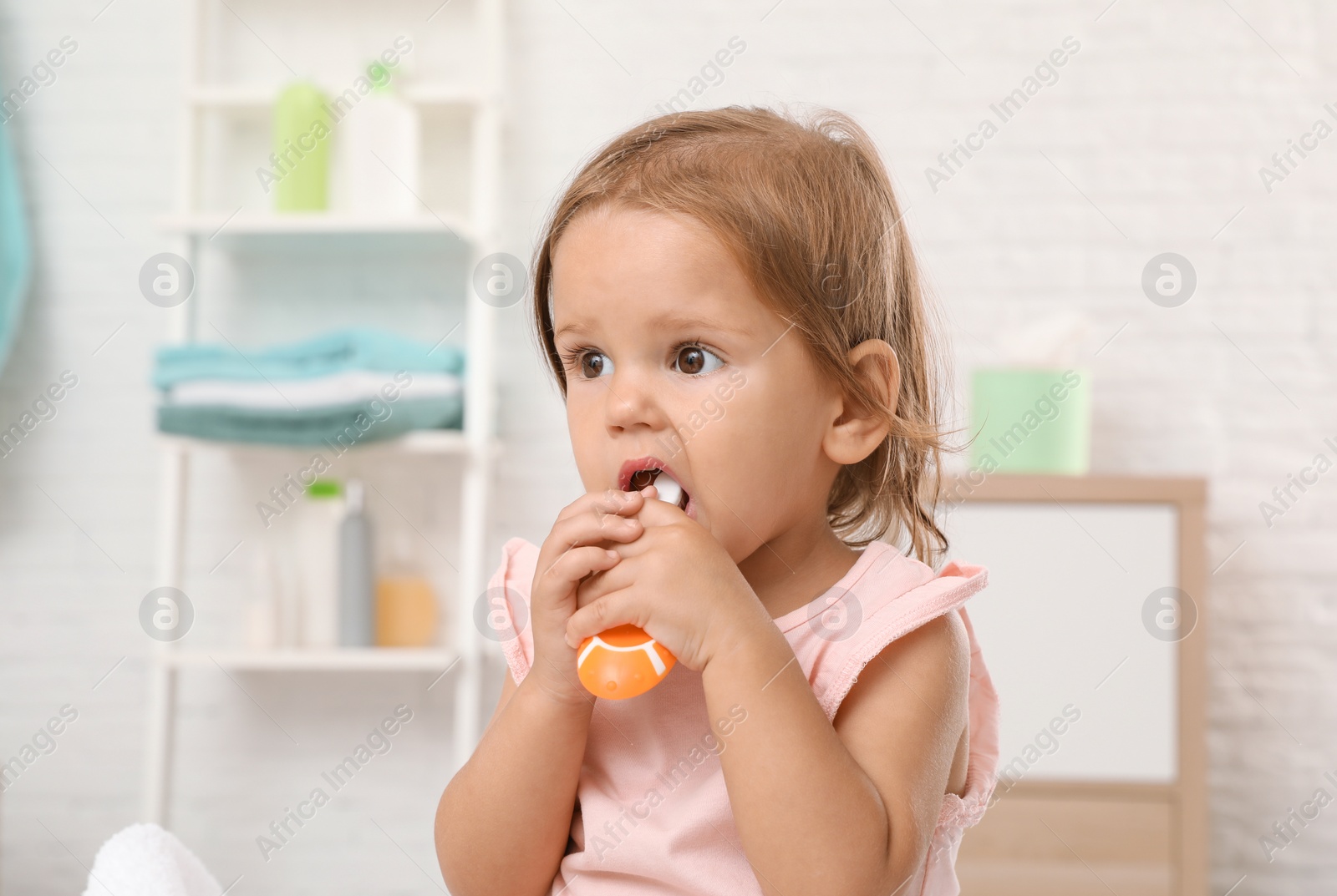 Photo of Cute little girl with toothbrush on blurred background