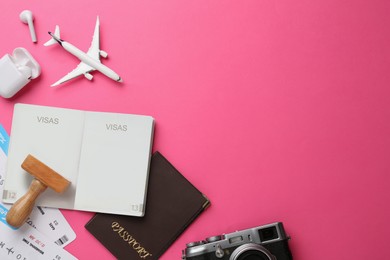 Photo of Flat lay composition with passports, stamp and flight tickets on pink background, space for text