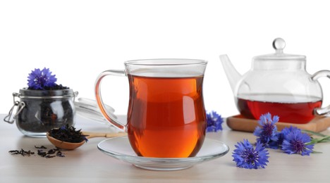 Photo of Cornflower tea and fresh flowers on wooden table