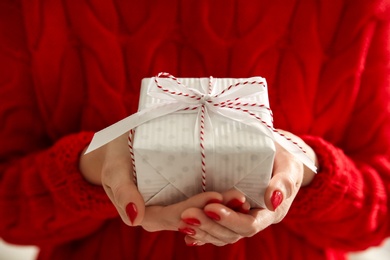 Woman holding white Christmas gift box, closeup