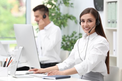 Photo of Female receptionist with headset at desk in office