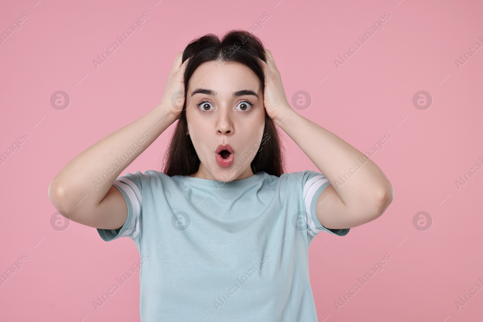 Photo of Portrait of surprised woman on pink background