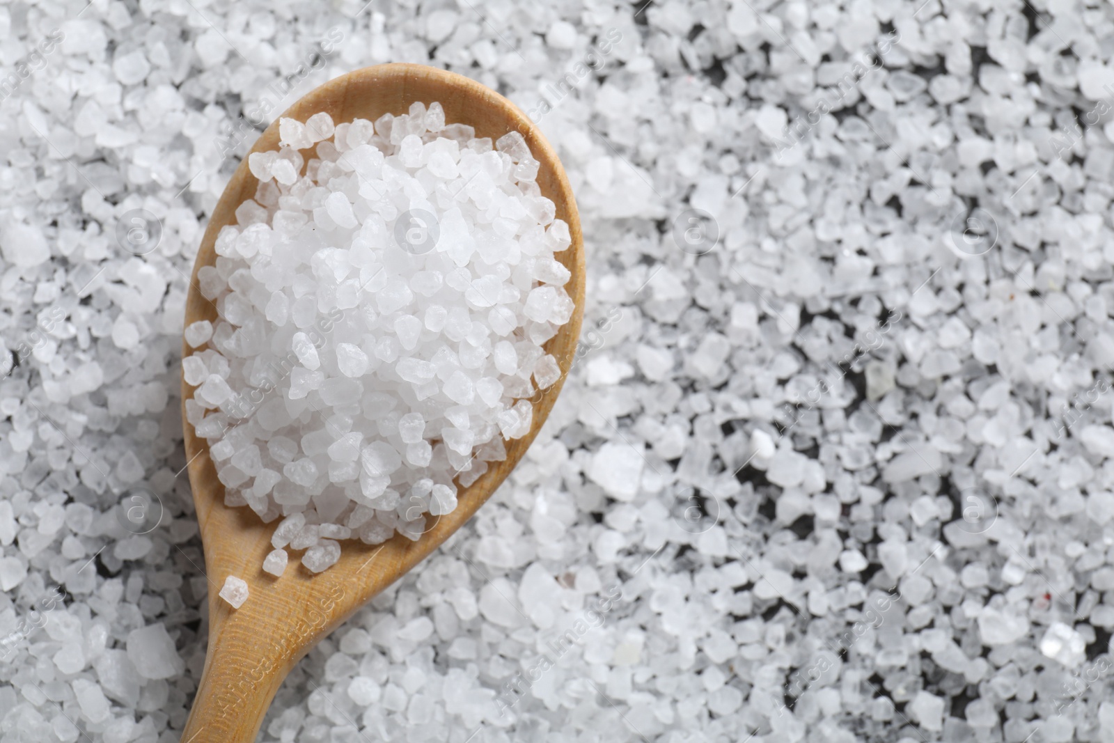 Photo of Natural salt and wooden spoon, top view