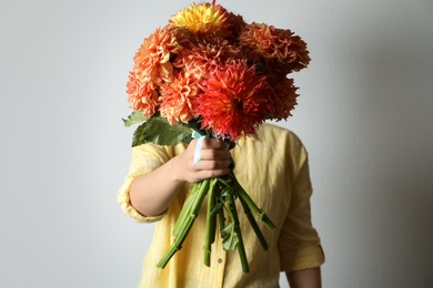 Photo of Woman with bouquet of beautiful dahlia flowers on grey background