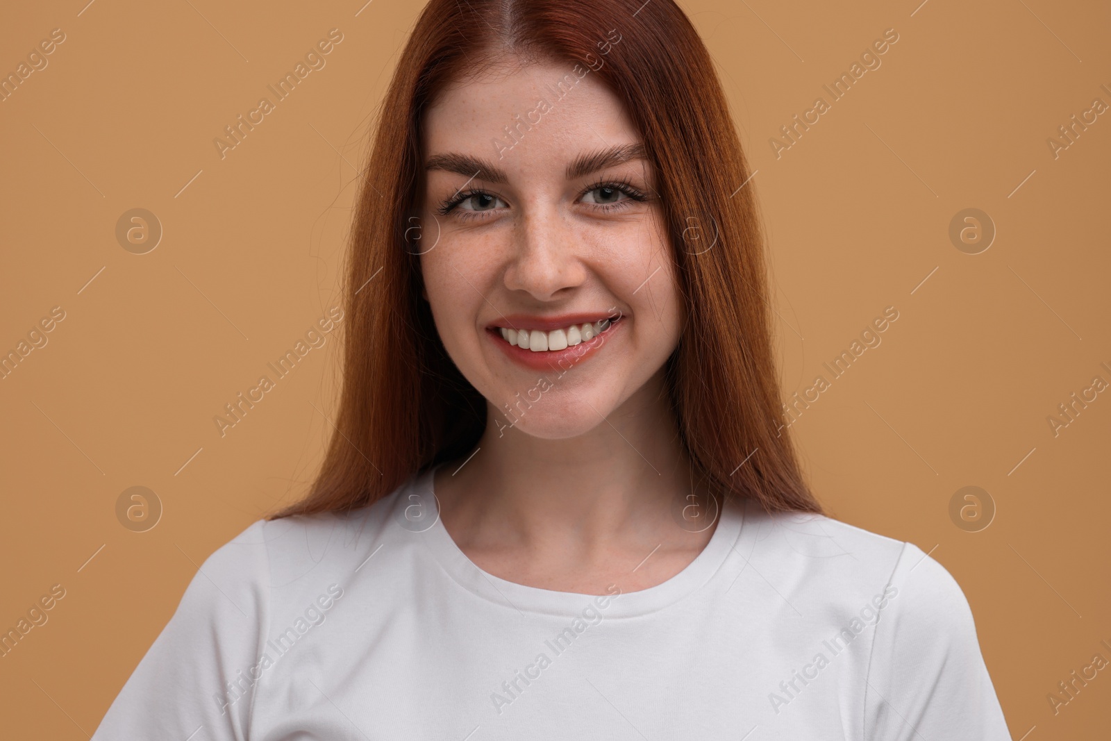 Photo of Portrait of smiling woman with freckles on beige background