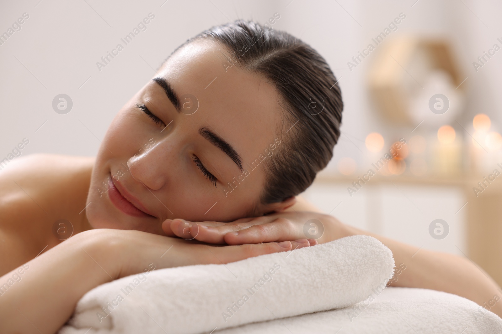 Photo of Beautiful woman relaxing on massage couch in spa salon