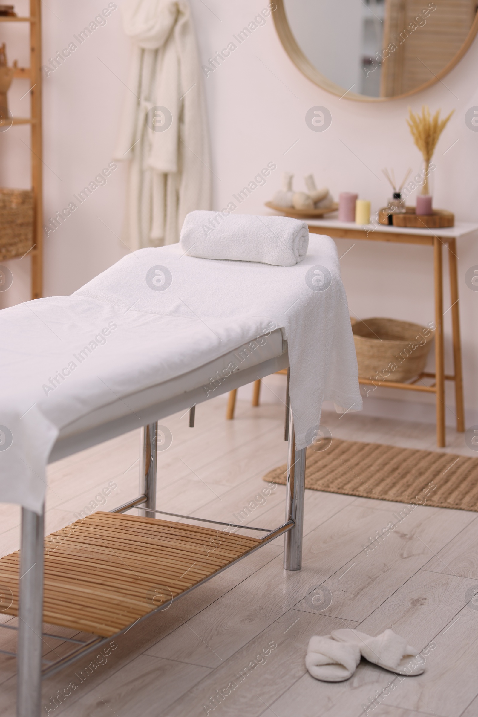 Photo of Comfortable massage table with clean towels in spa center