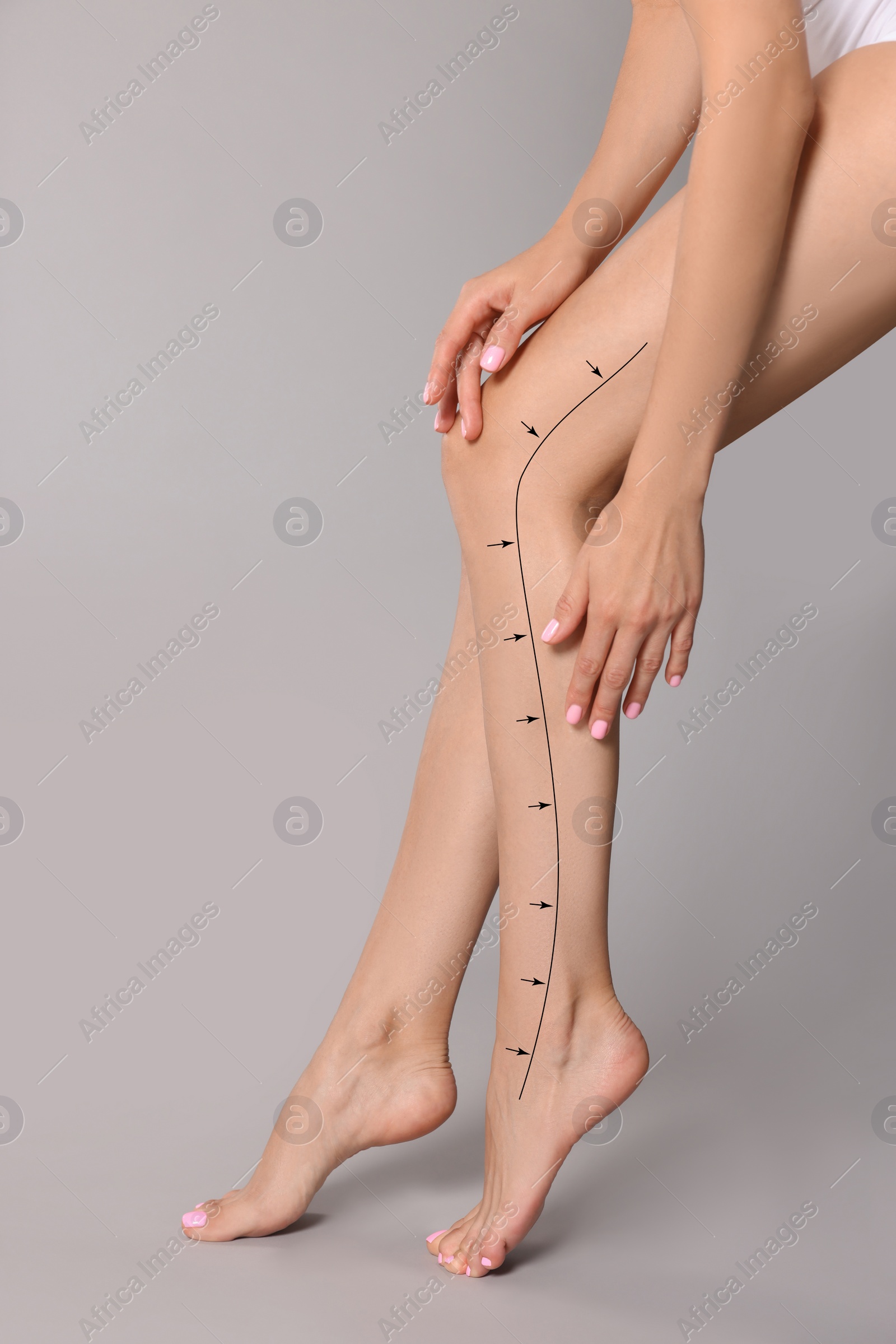 Image of Epilation guide - how to remove hair in proper direction. Woman with drawn lines and arrows on her beautiful smooth legs against light grey background