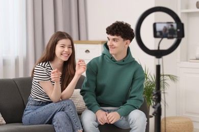 Smiling teenage bloggers talking while streaming at home