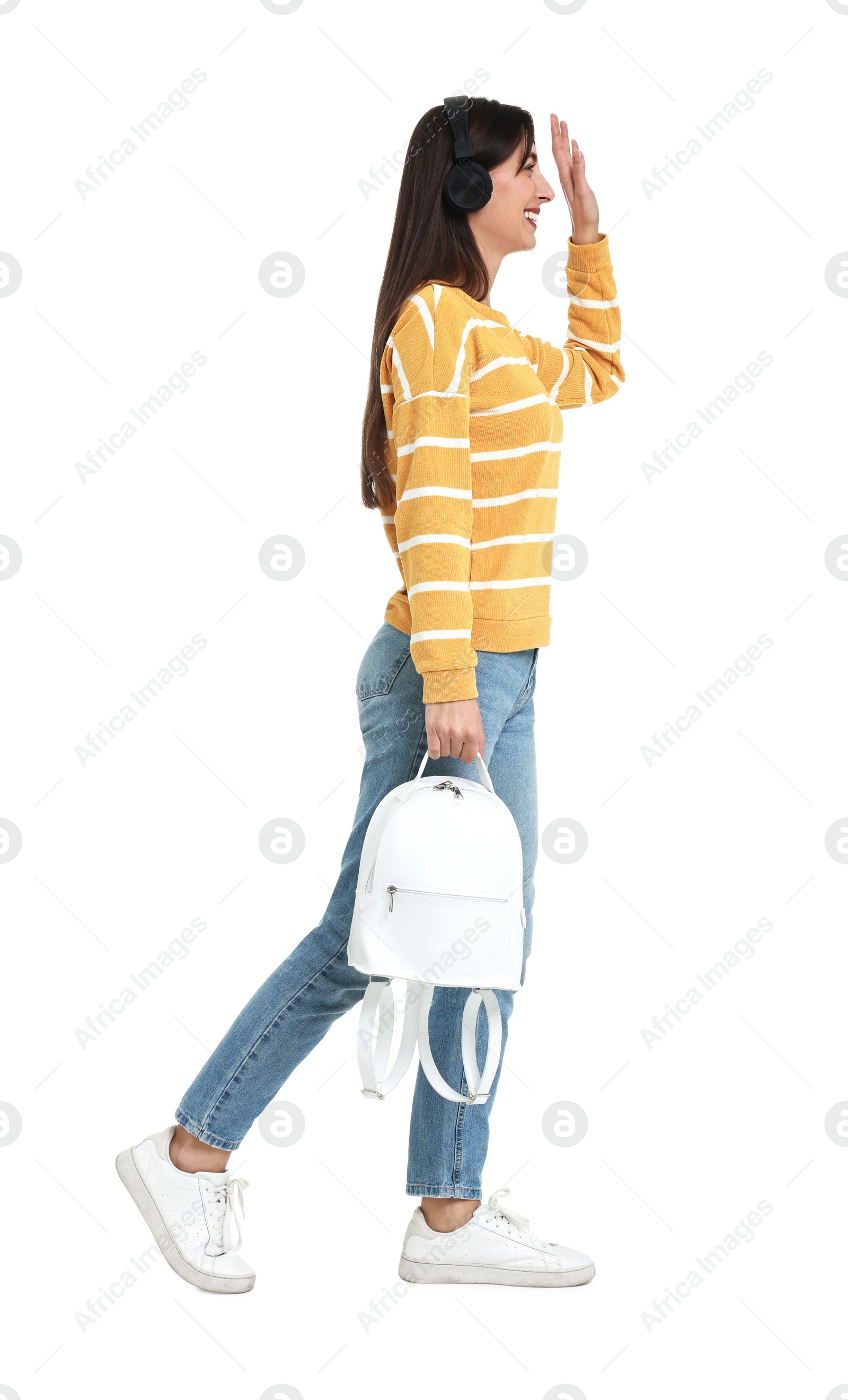 Photo of Happy woman with headphones and backpack on white background